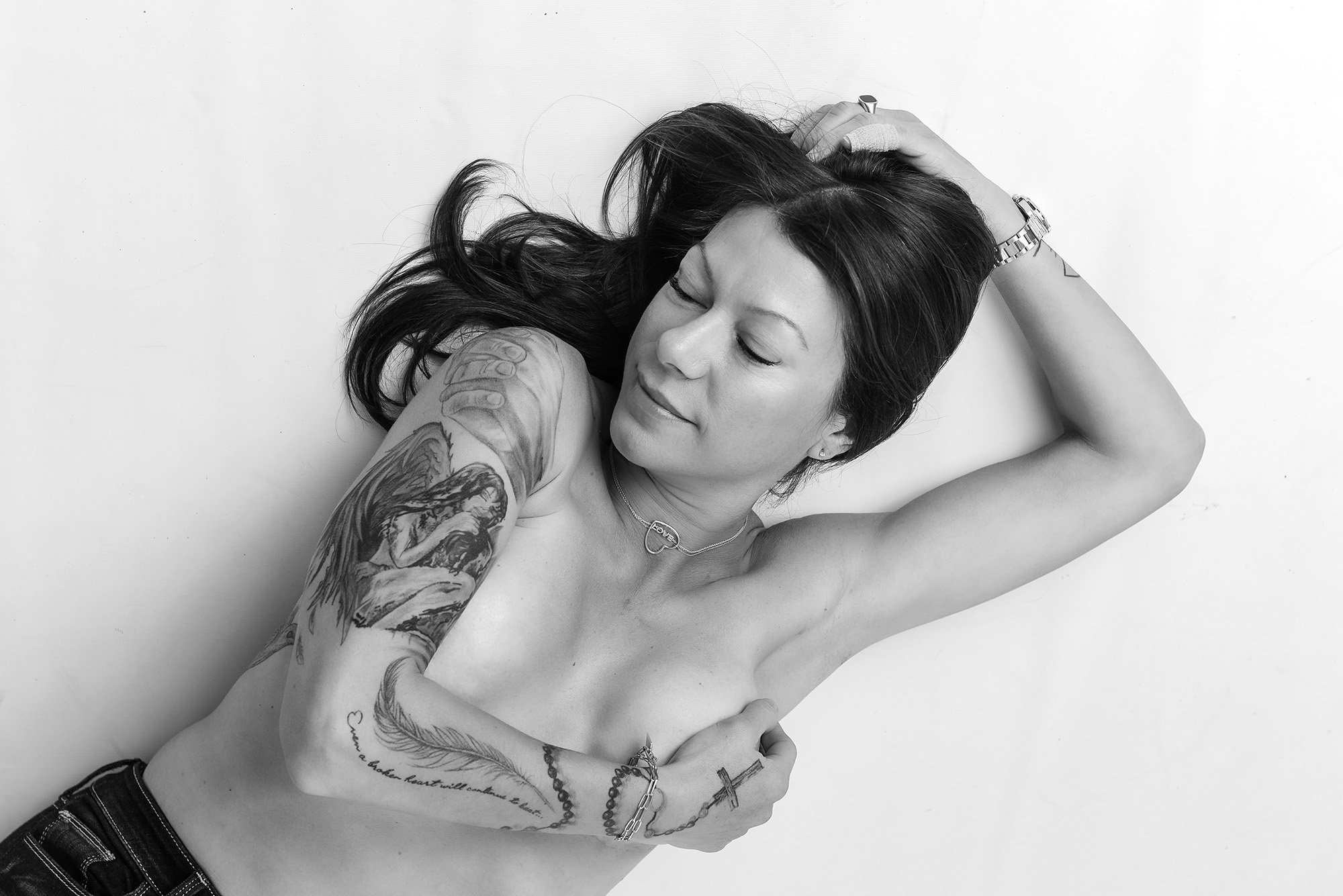 Toronto boudoir photography. A striking woman topless with tattoo's