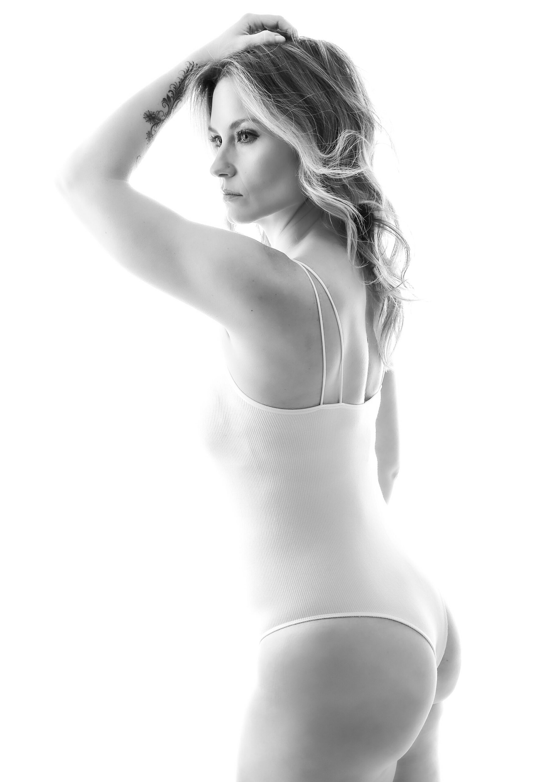 Toronto boudoir photography. A striking woman in a white body suit