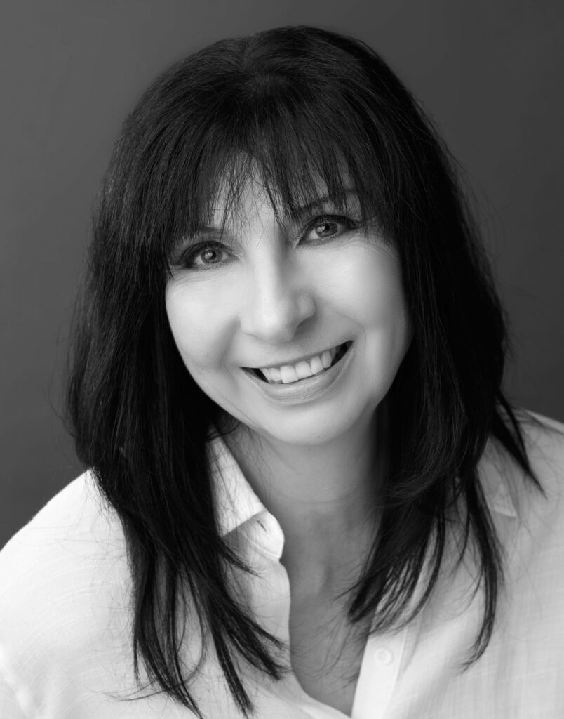 A professional headshot of a woman smiling, taken by a glamour photographer.