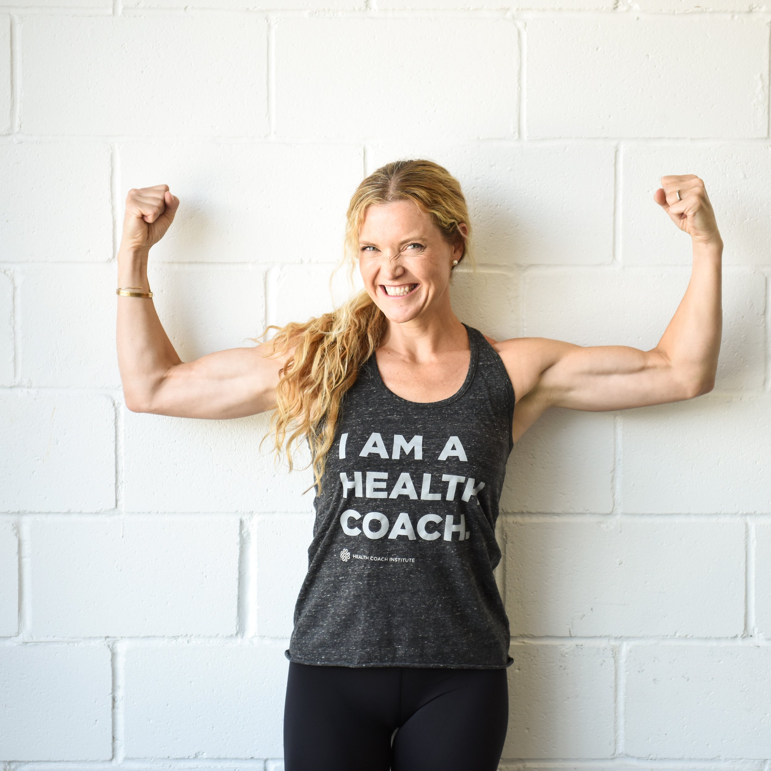 An empowering health coach flexing her muscles in a Toronto studio.