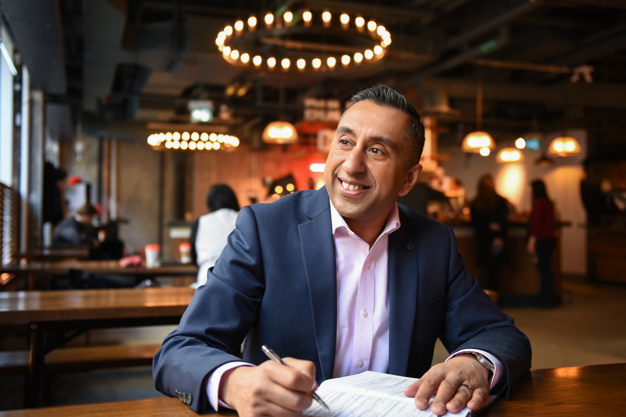 Businessman smiling while working in a Toronto cafe