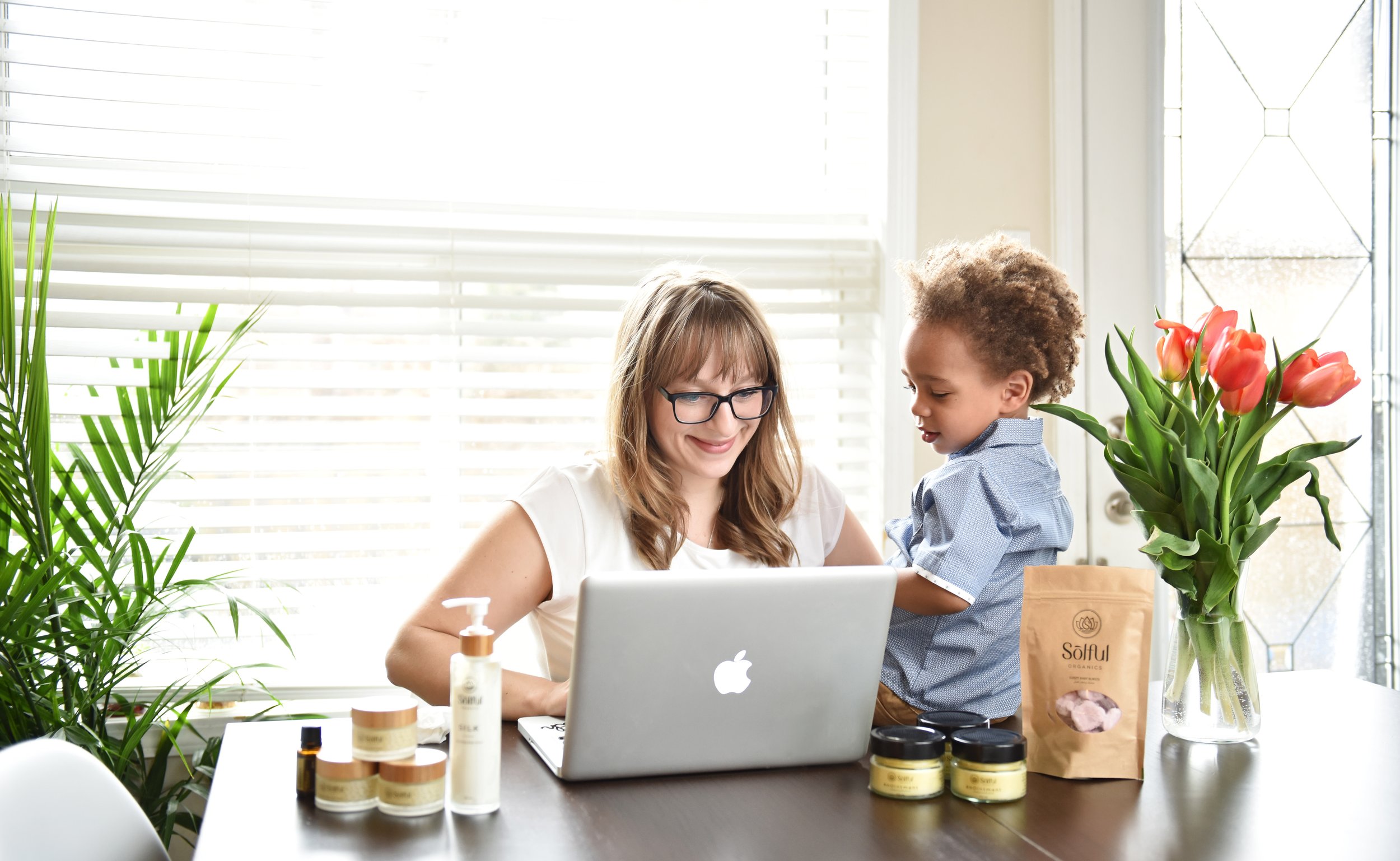 An entrepreneur mother working from home in Toronto, with her child helping