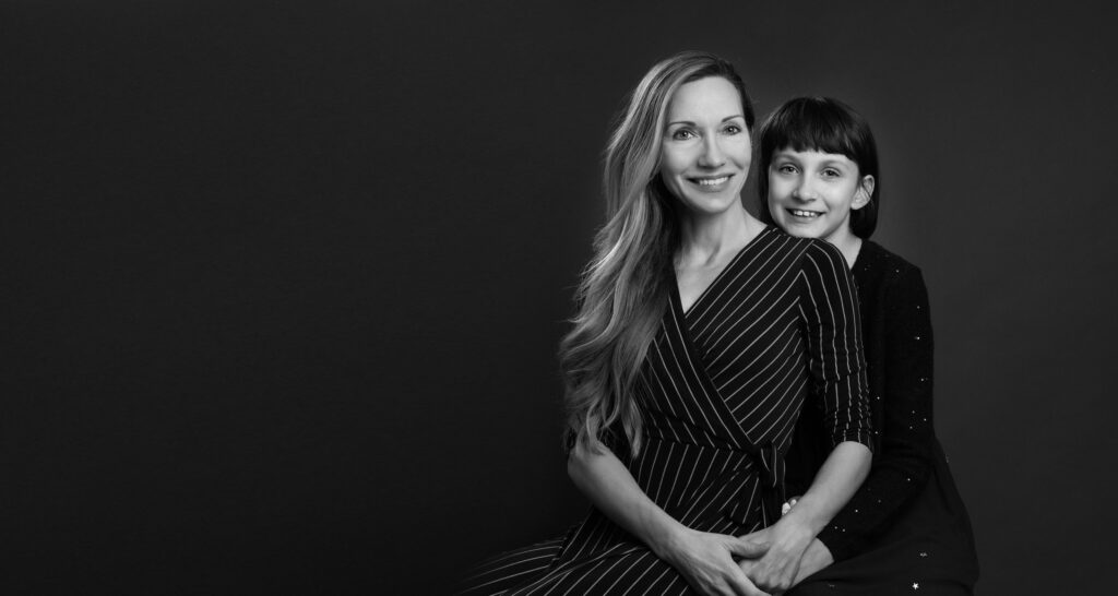 A mother and daughter enjoying a professional mother daughter photoshoot, smiling together.