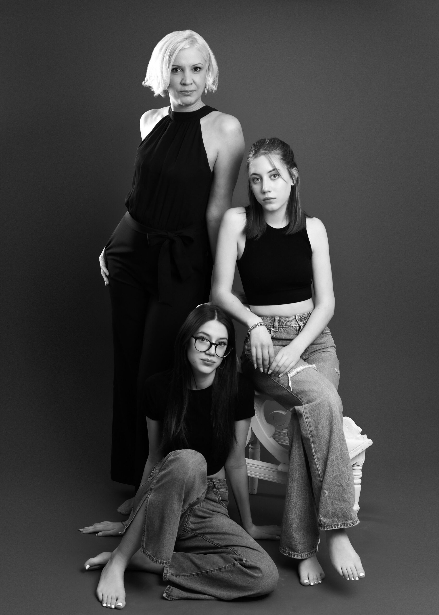 A mother and her two daughters posing confidently for a family photoshoot.