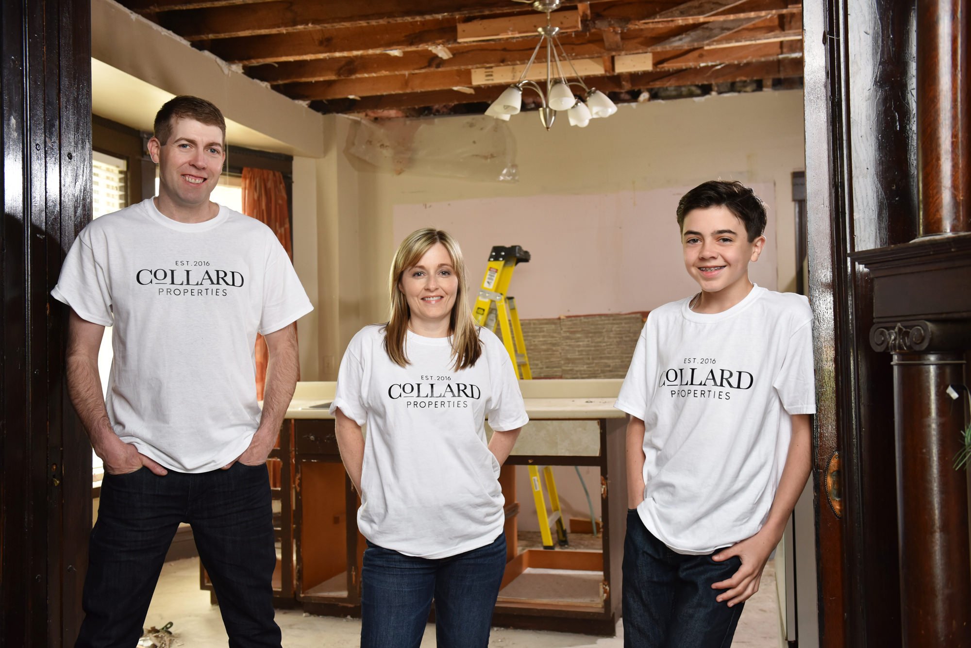 A family business team in Toronto wearing branded t-shirts standing in a home renovation project.