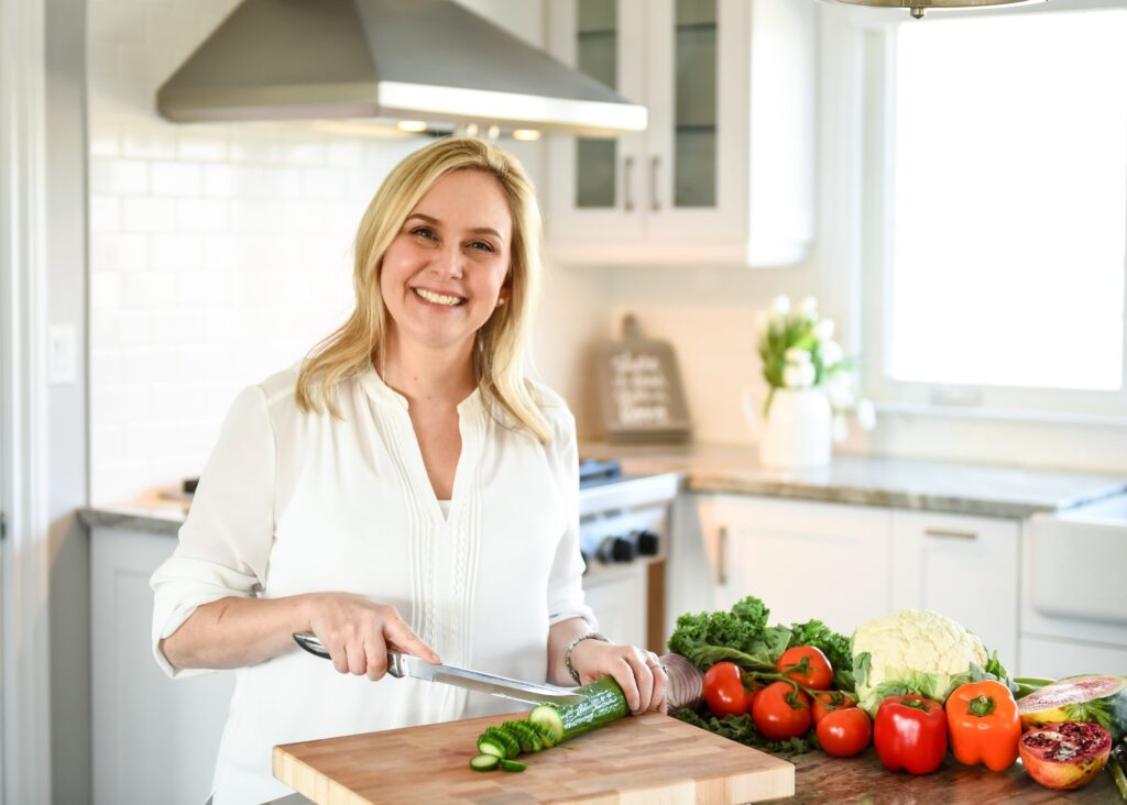 Health coach training clients in a bright white kitchen, demonstrating a healthy eating with a focus on wellness. best personal branding 