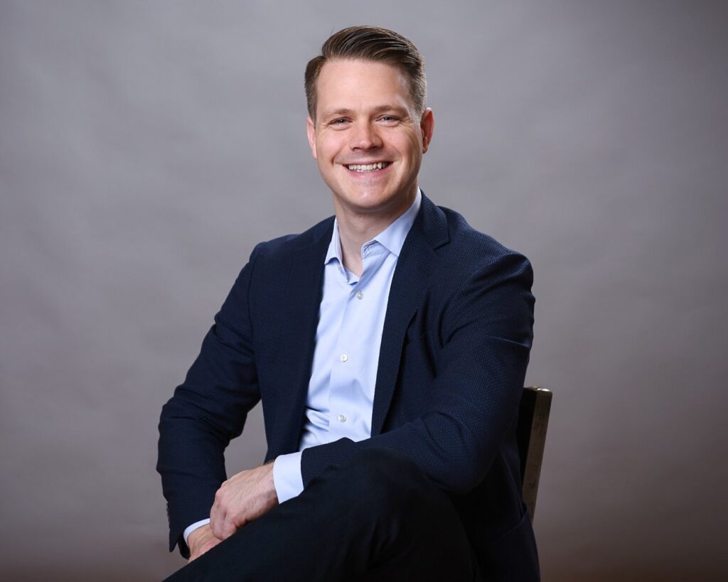 Professional headshot of a man in a dark blazer and light blue shirt, exuding confidence and professionalism - headshots Toronto.