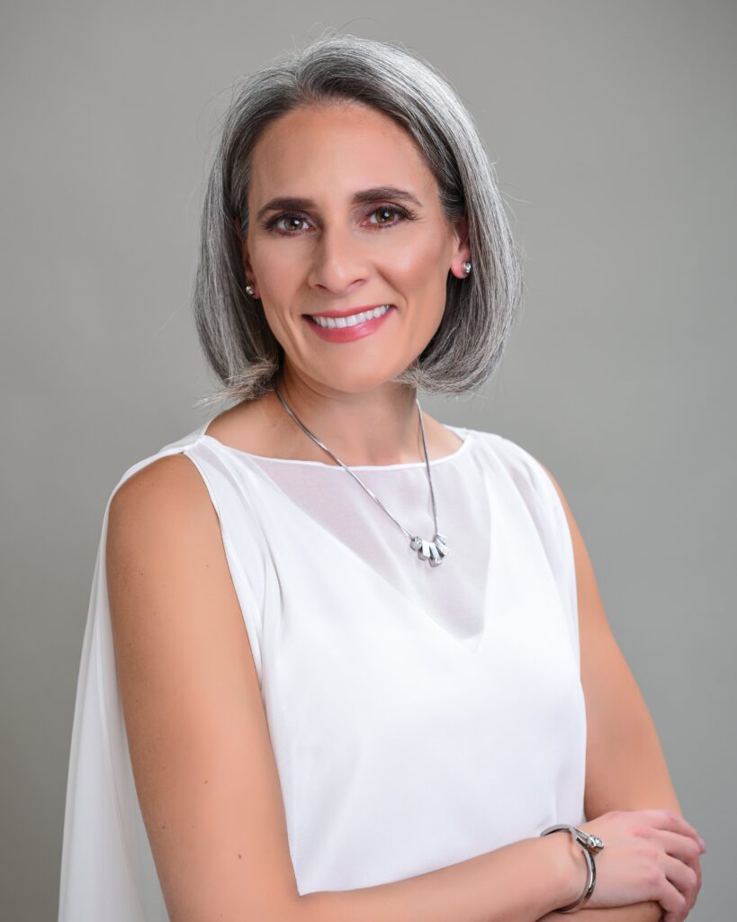 Professional headshot of a woman in white attire, showcasing her friendly and confident demeanor - headshots Toronto.