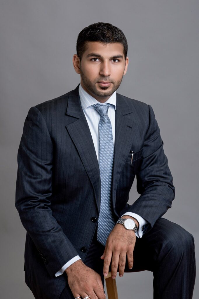 A corporate professional in a navy blazer and white shirt ready for a LinkedIn headshot, exemplifying the ideal dress code for professional photos