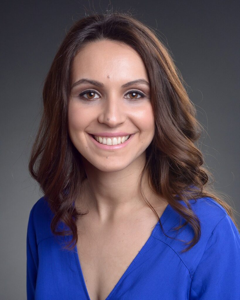 Professional headshot of a young woman in a blue blouse, radiating a welcoming and approachable aura - headshots Toronto.