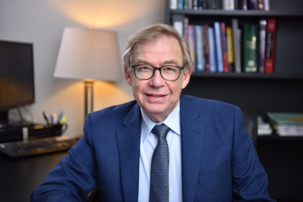 Professional man sitting confidently at a desk, demonstrating tips for looking confident in headshot photos