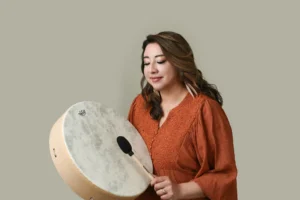 Female counselor engaged in a drumming session, emphasizing holistic therapy practices.