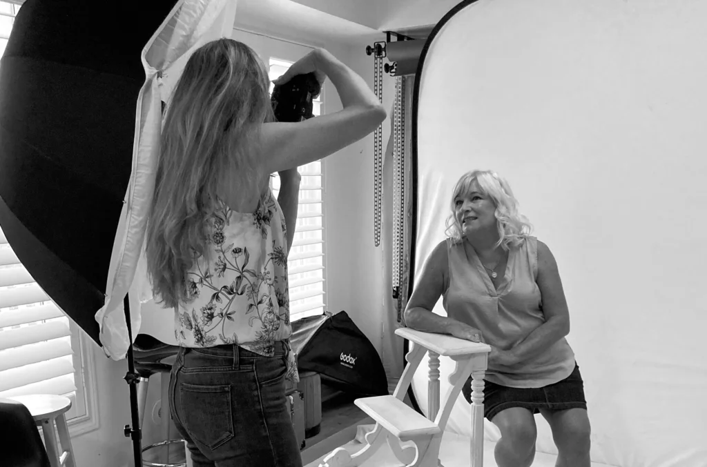 Photographer Carla Morgado working with a client in a studio setting, demonstrating in-studio preparation techniques for a photoshoot, including posing guidance and lighting setup.